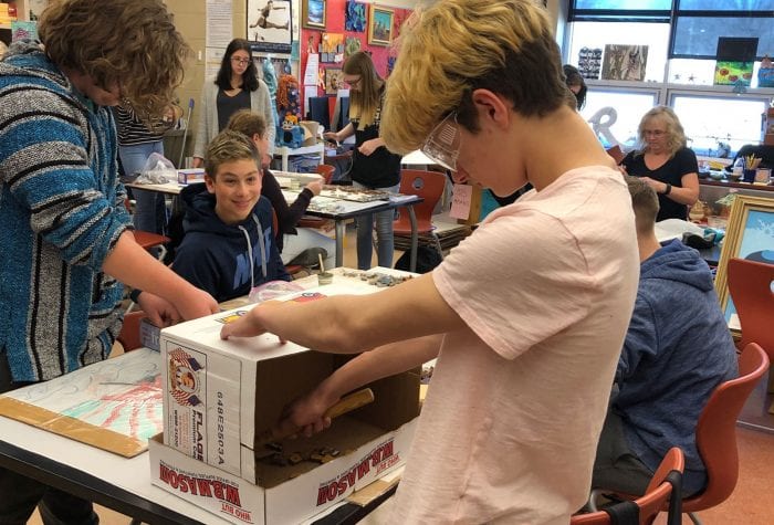 A student breaks tiles which will be used in his mosaic