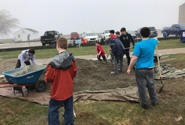Scouts load wheelbarrows with aggregate base layer for labyrinth